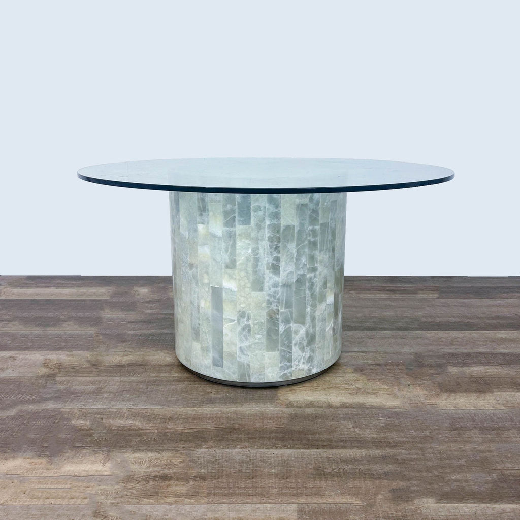 Round glass table with a travertine stone drum base from Artistica's dining set collection.