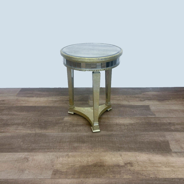 Mirrored round table with wood frame on a wood floor.