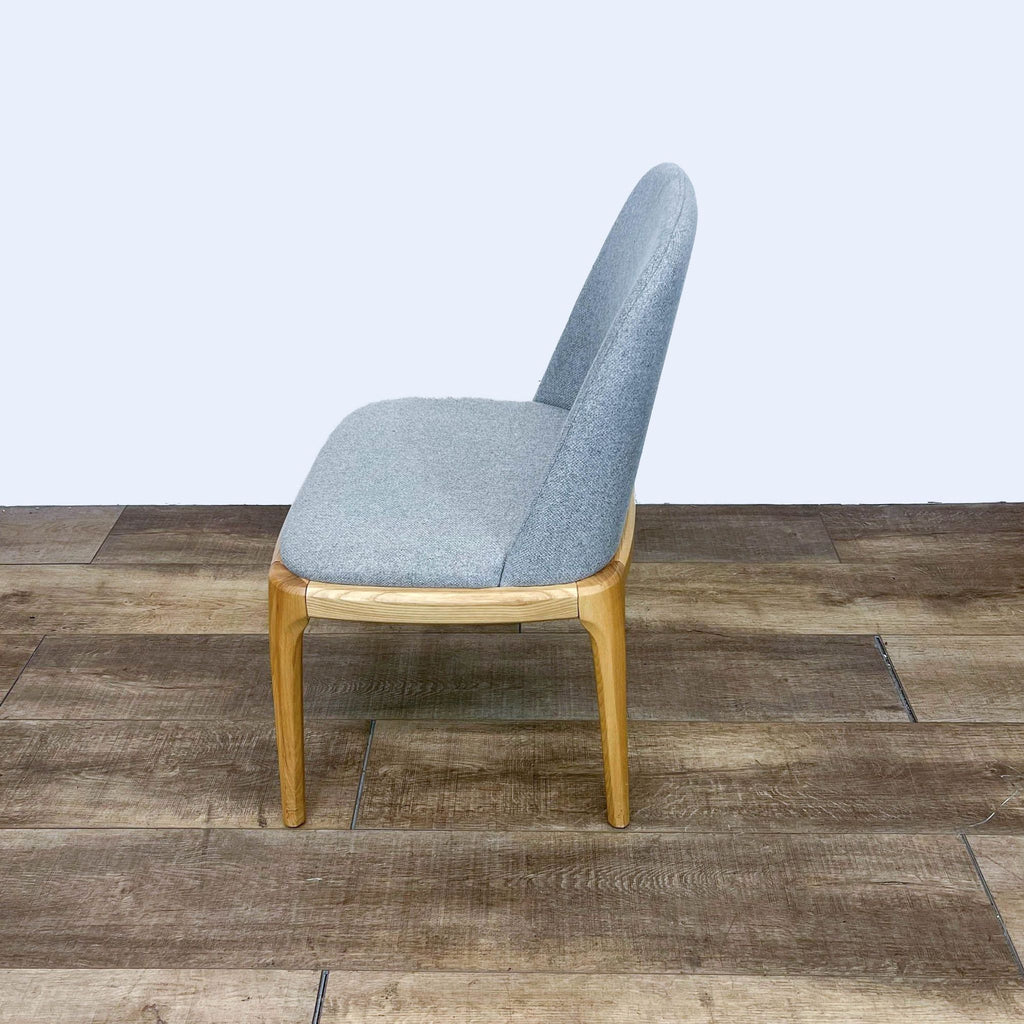 Side view of Reperch dining chair featuring sleek, splayed wooden legs and upholstered seat.