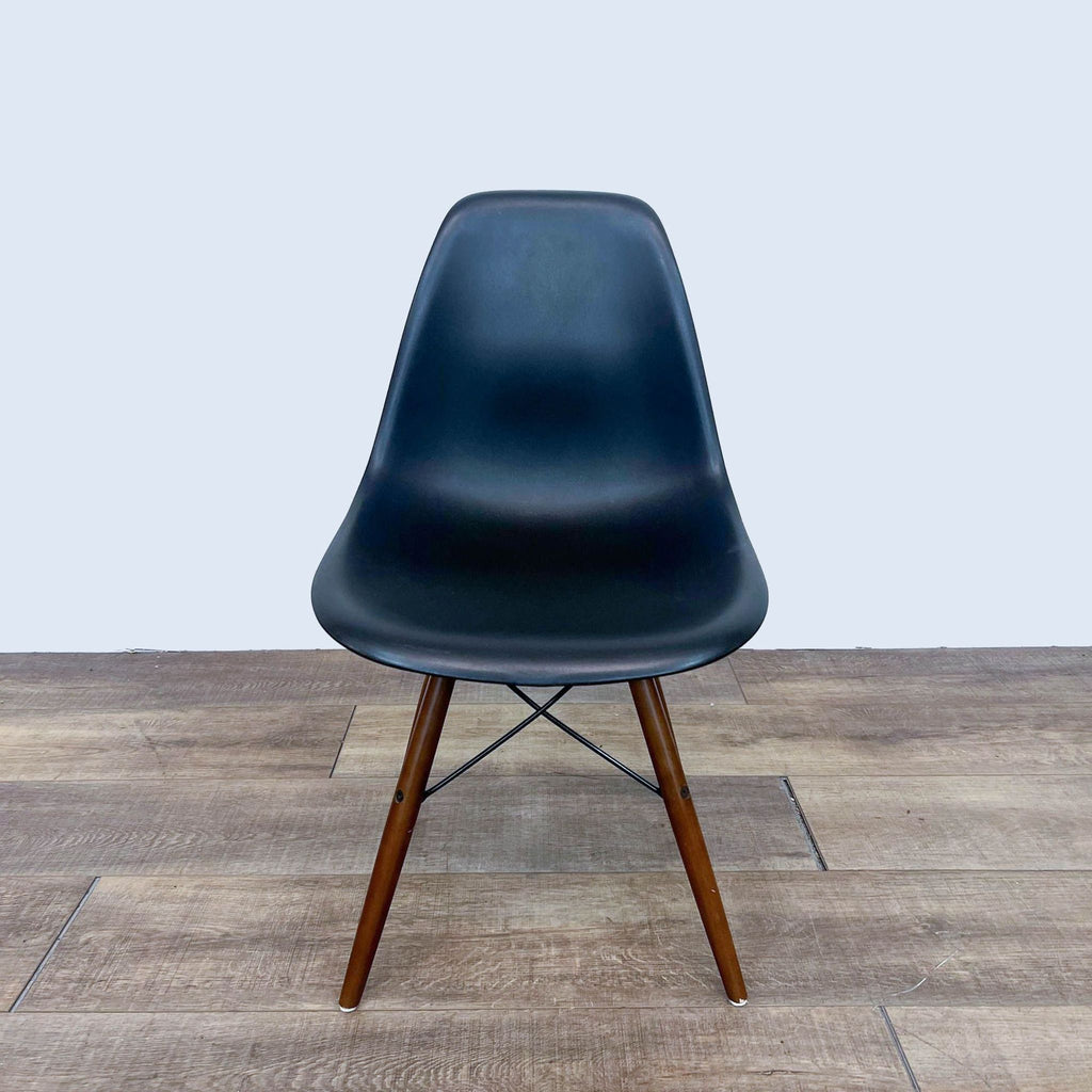 Front view of a black dining chair with a wood and metal Eiffel style base.