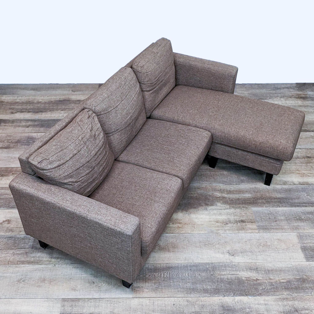 Top view of Reperch sectional sofa with reversible chaise on wooden floor.