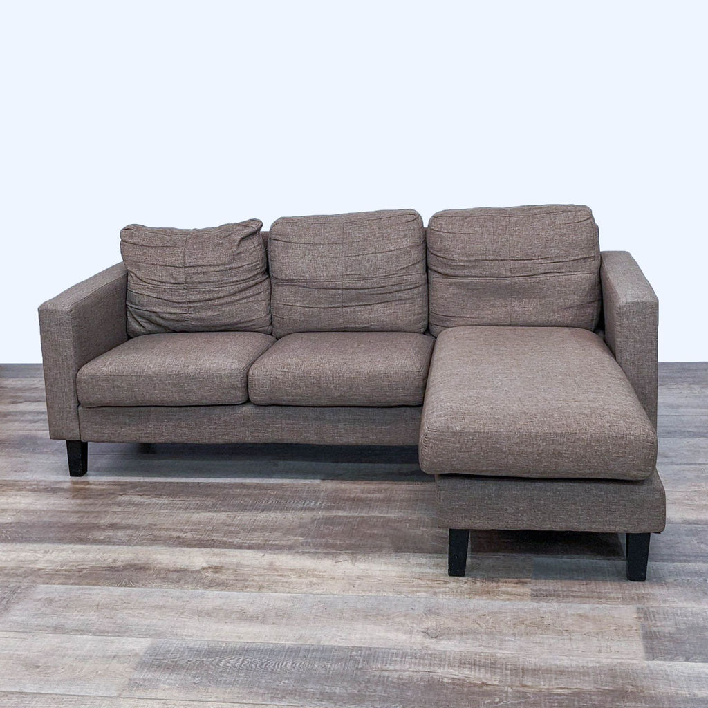 Reversible chaise sofa with narrow arms and dark feet by Reperch, shown from front.