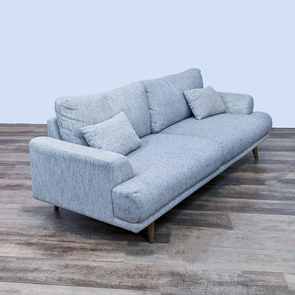 Side angle of a gray 3-seat contemporary sofa with sleek design.