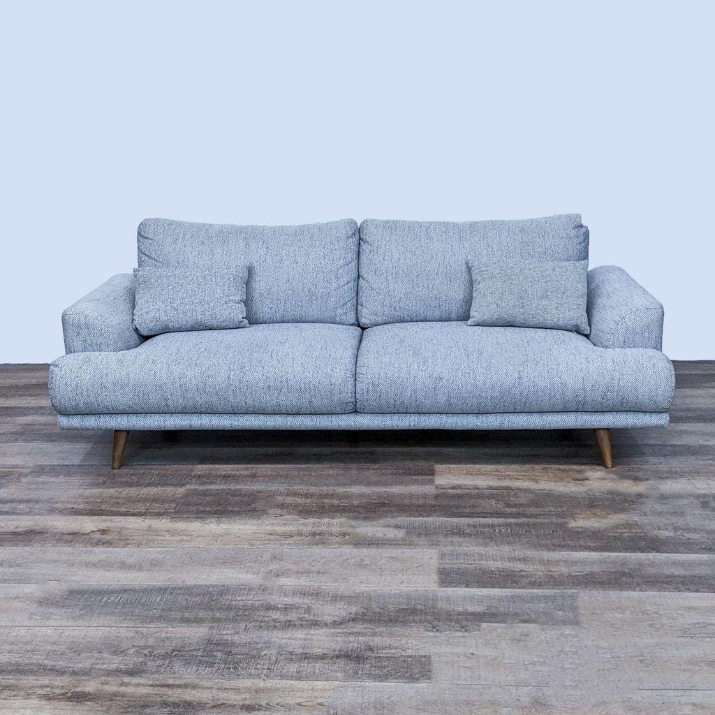 Front view of a modern 3-seat sofa with block arms and tapered legs.
