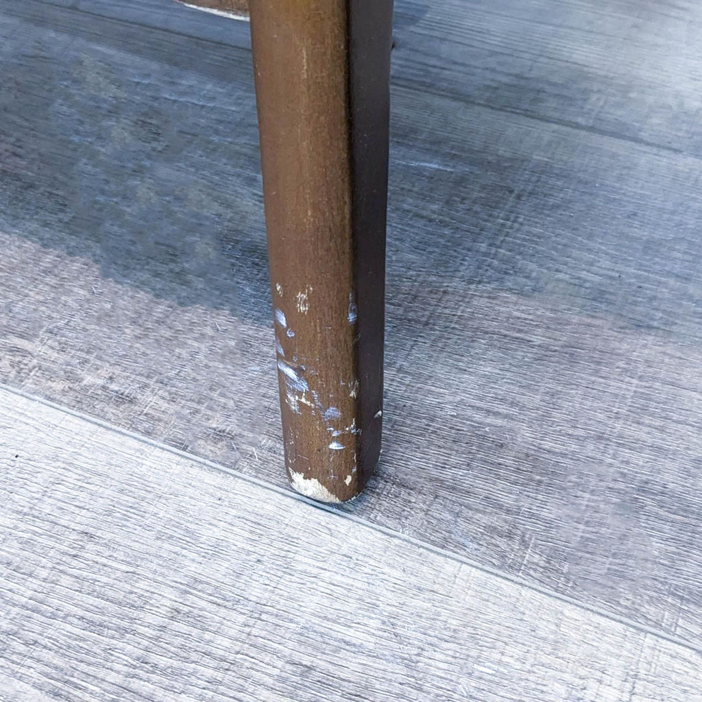 Close-up of Olliix coffee table leg with visible wear.