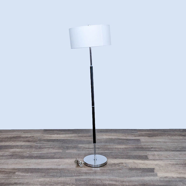 Sleek Reperch floor lamp with a white shade on a wooden floor.