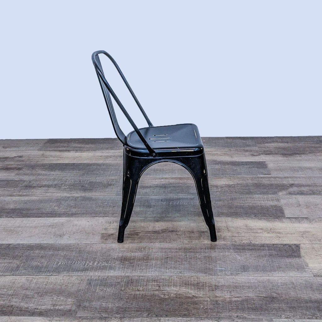 the chair is made of steel and has a black seat.