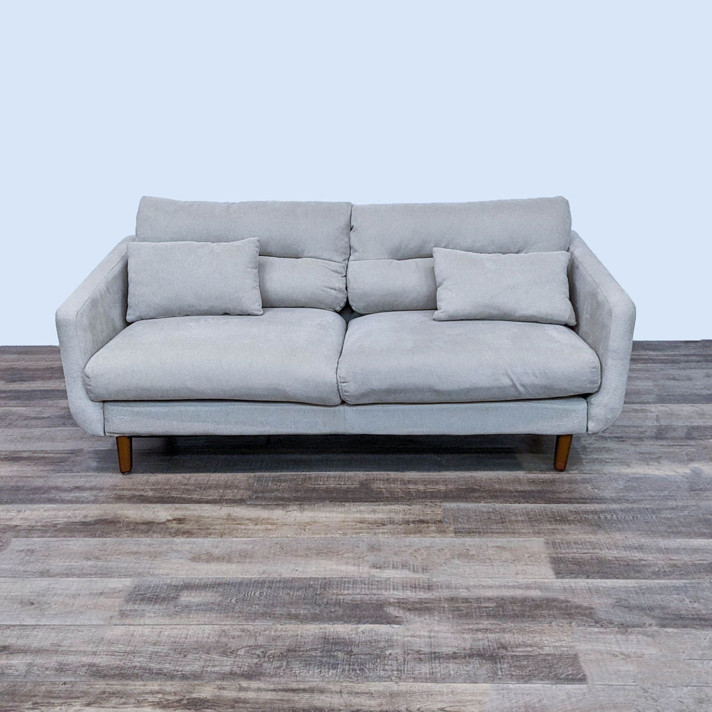 Reperch 3-seat beige sofa with narrow arms, wood feet, and accent pillows.