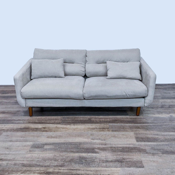 Reperch 3-seat beige sofa with narrow arms, wood feet, and accent pillows.