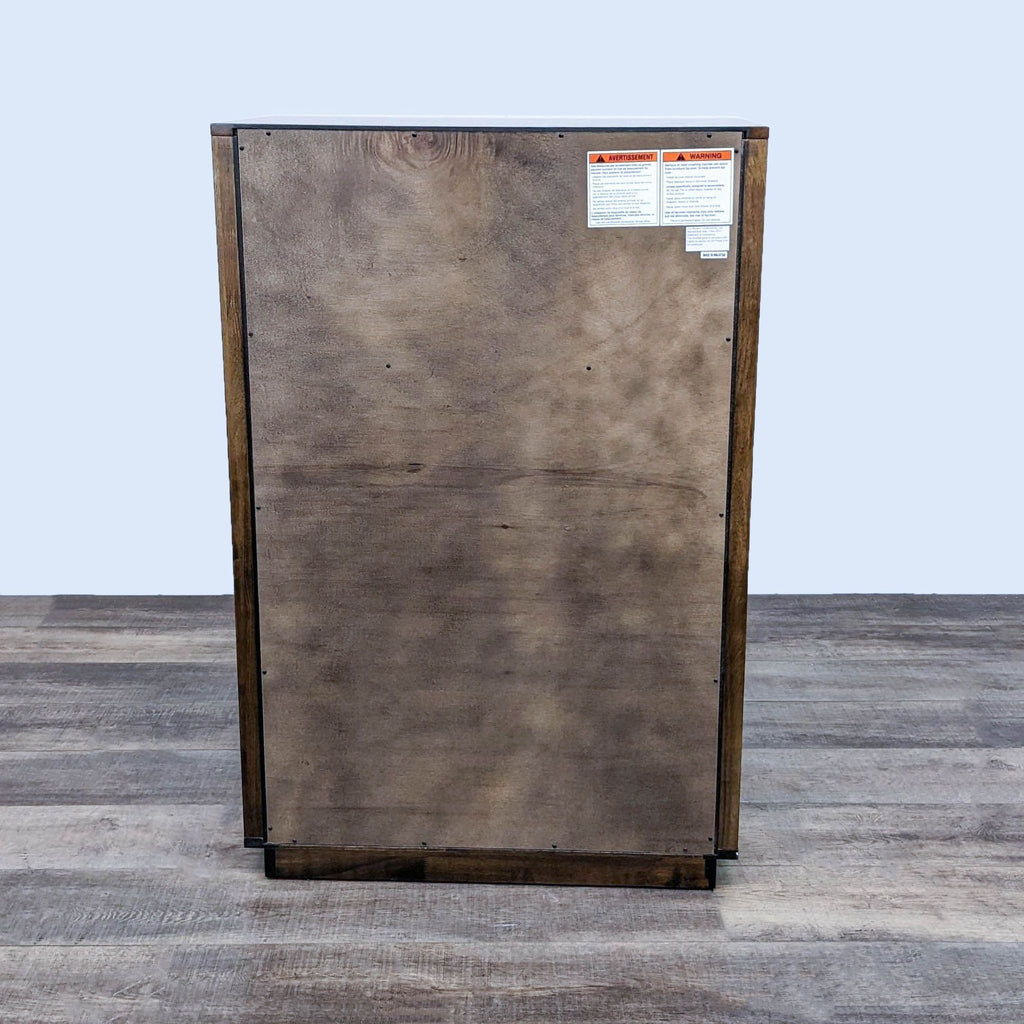 Back view of the Linea High Chest, showcasing wood finishing and warning labels.