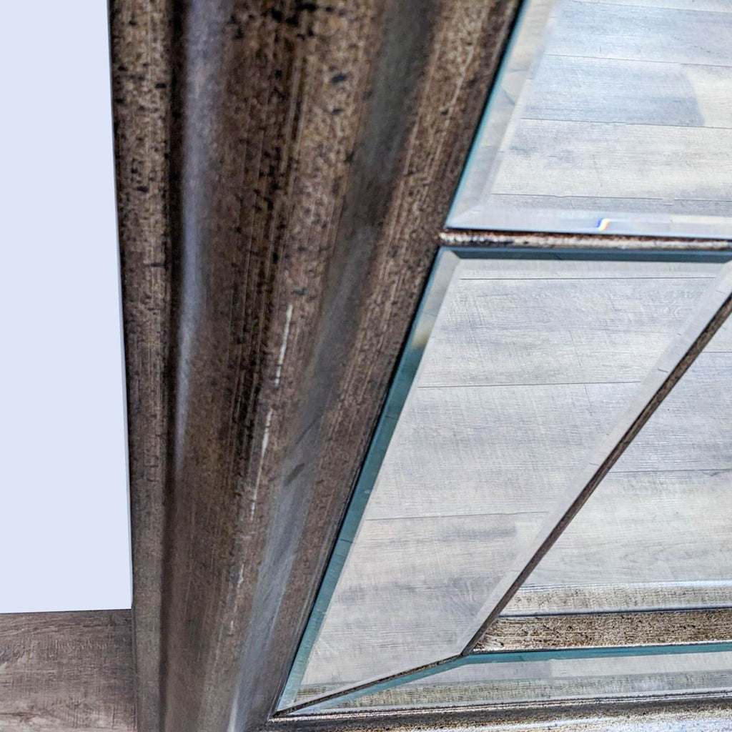 Close-up of bronze frame on Reperch mirror, showcasing beveled glass and refined detailing.