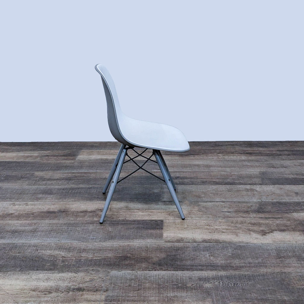 Side profile of a sleek, modern dining chair on wooden floor.