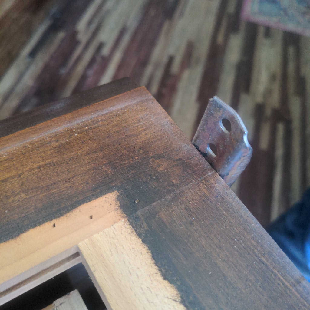 2. Close-up of a wooden dresser corner showing a metal drawer guide and wood grain detail.  
