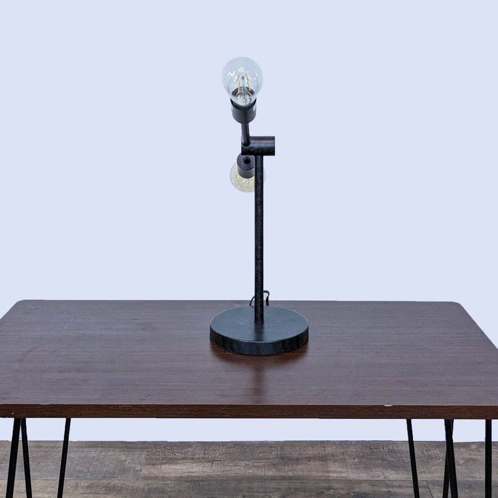 Front view of Reperch lamp on table, showing sleek construction.