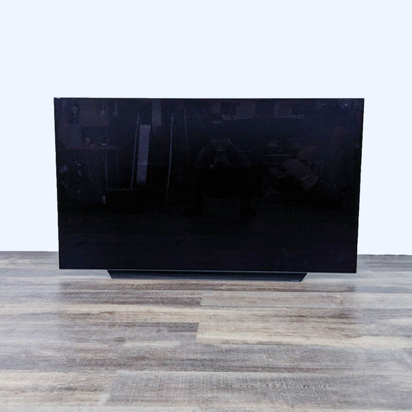 Front view of an LG TV with a dark, blank screen.