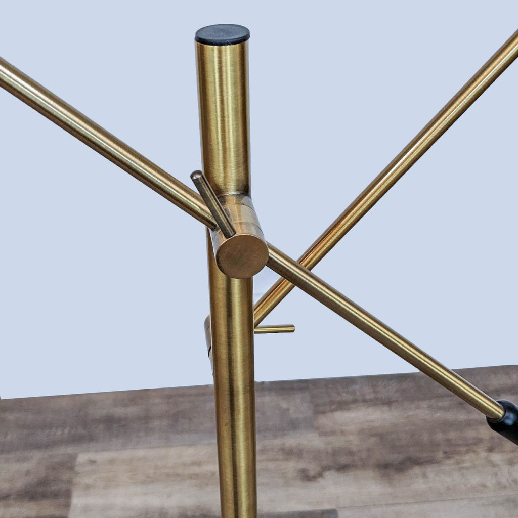 Brass joint and arms detail of a Reperch floor lamp, highlighting the adjustable features.