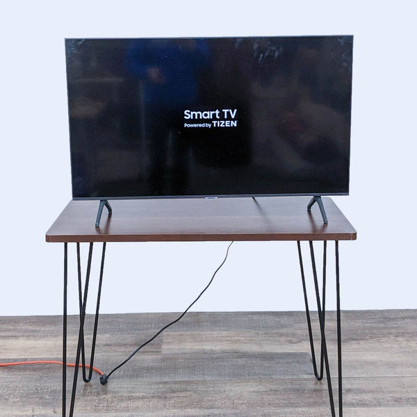Samsung smart TV with Tizen OS on a wooden table.