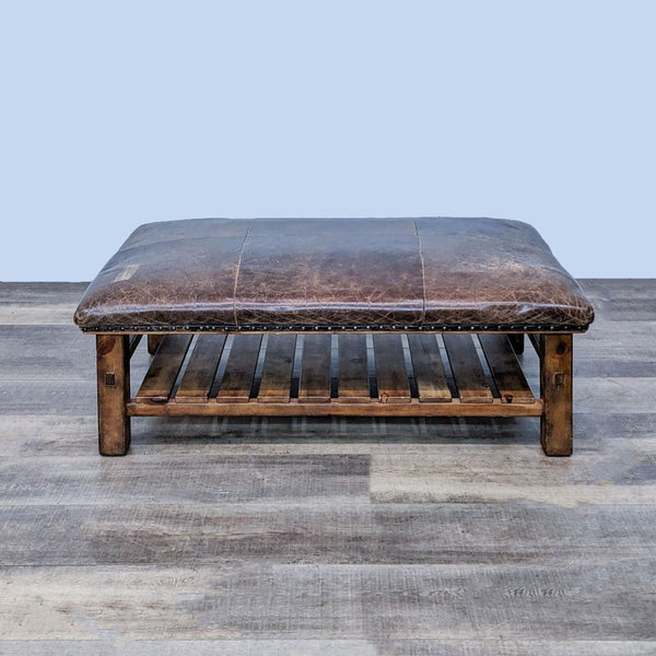 1. Large rectangular brown distressed leather ottoman on wood frame with shelf and nail head accents, front view.