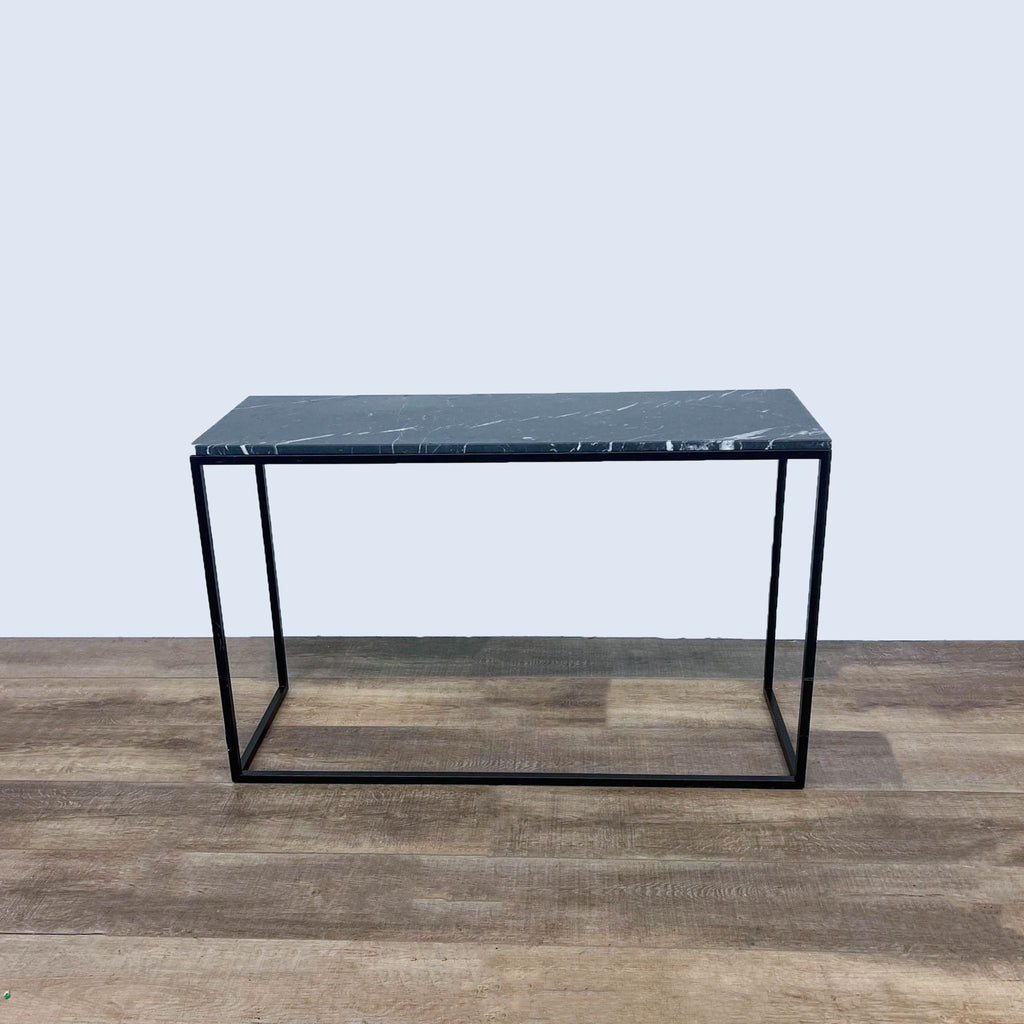 Sleek side table with black marble top and thin metal frame.