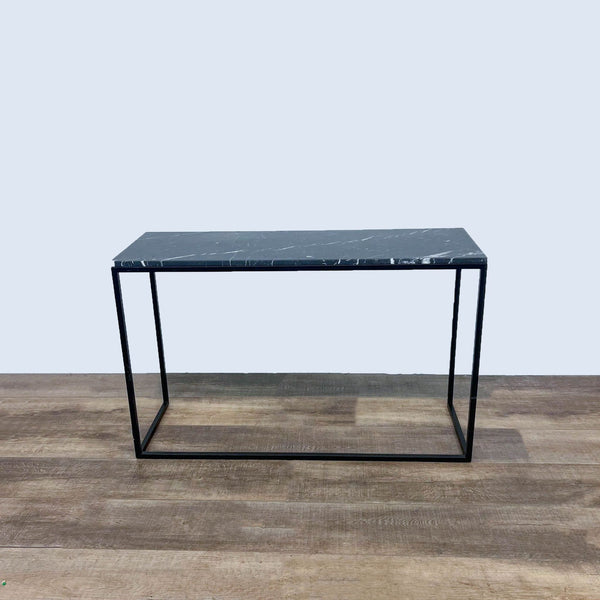 Sleek side table with black marble top and thin metal frame.