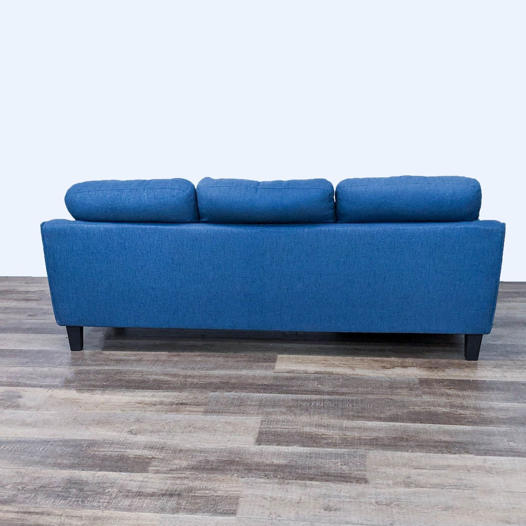Back view of blue sectional sofa with cushioned backrest.