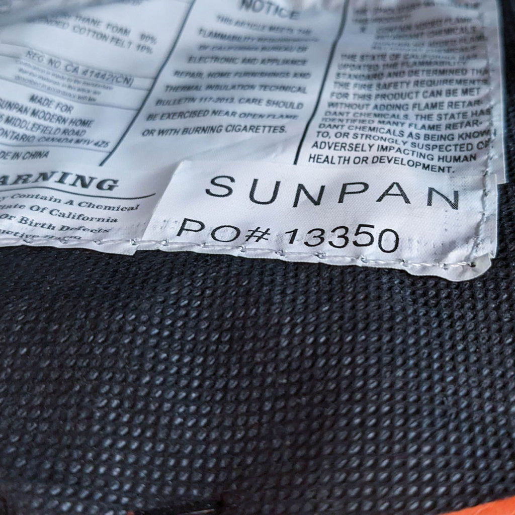 Label on the bottom of Sunpan orange ottoman showing product details.