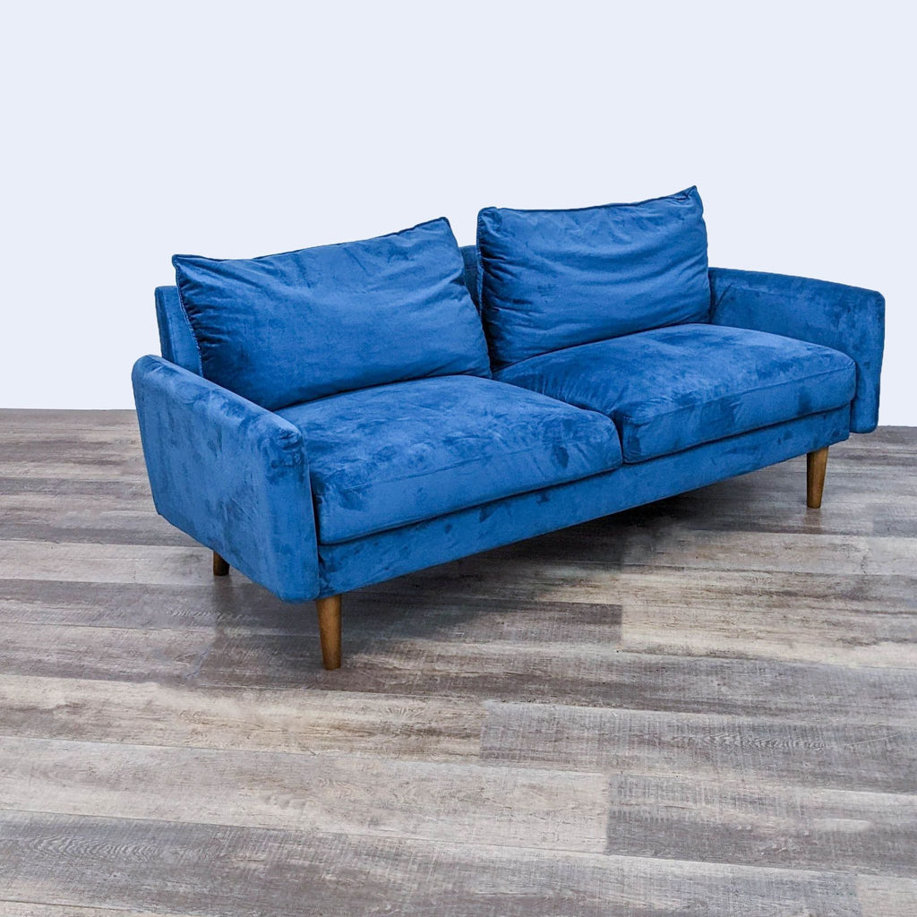 Three-seat compact blue sofa by Reperch with sleek design and wooden legs on display.