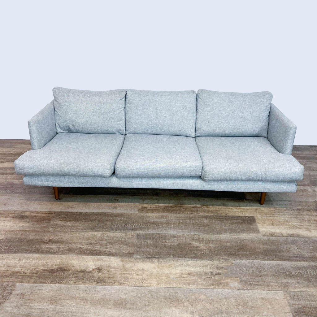 1. Modern light gray 3-seat sofa by Article with narrow arms and walnut finish tapered wood legs on wood floor.  