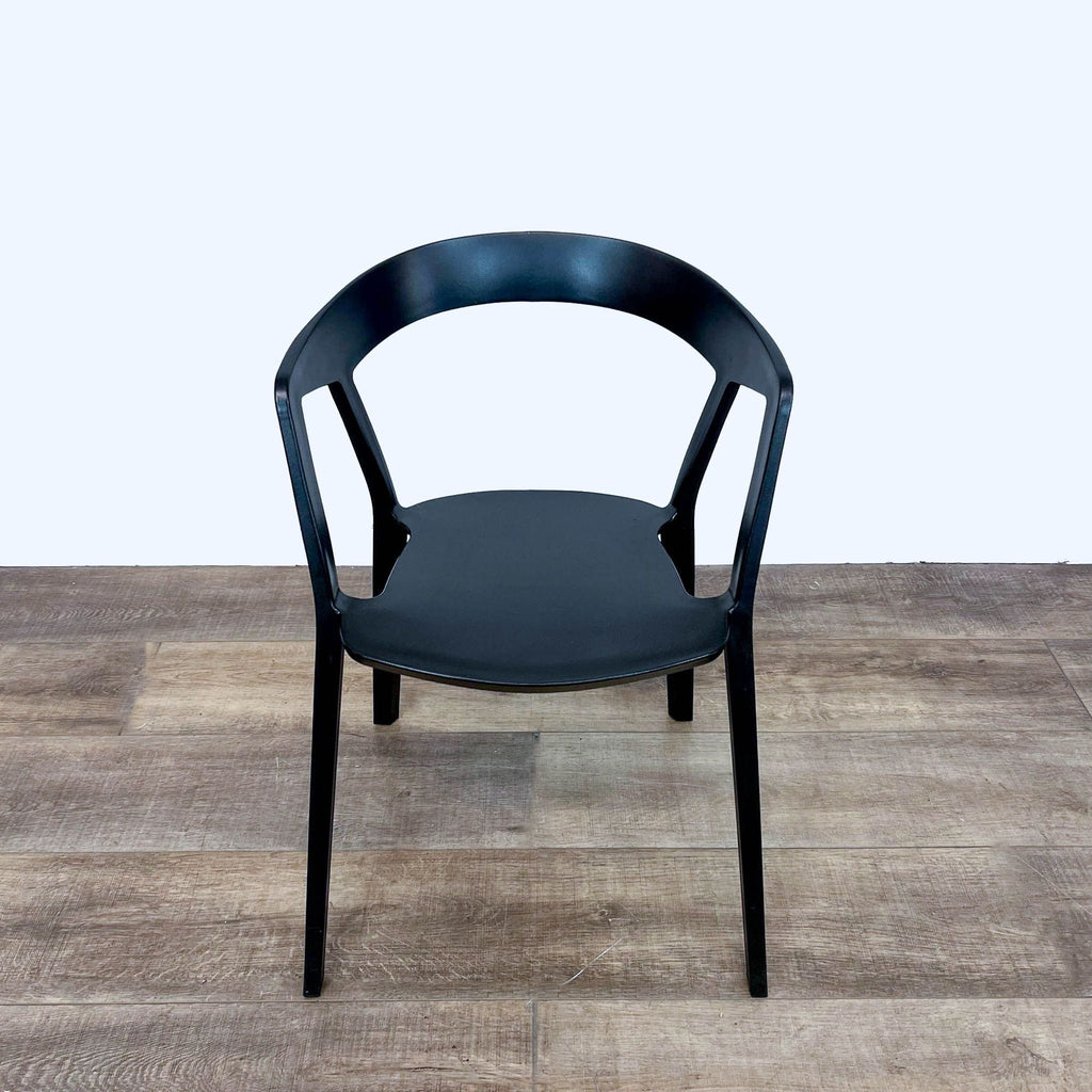 Angled view of stackable black Compas Armchair with sloped back by Rove Concepts.