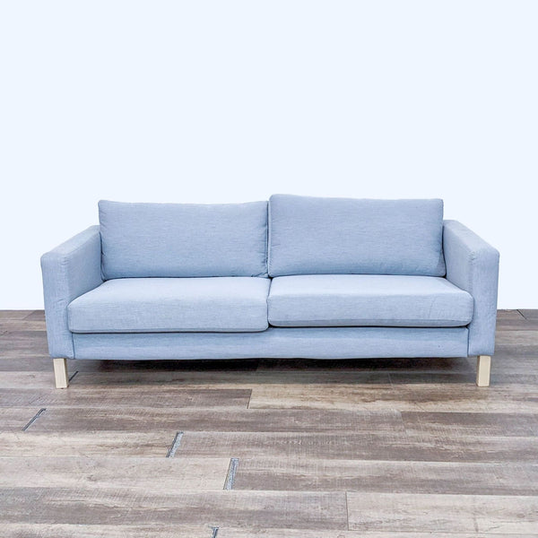 Light blue 3-seat Ikea sofa with track arms and light finish feet.