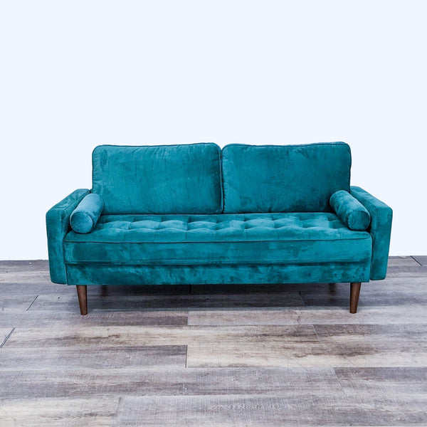 Teal tufted sofa with narrow arms and tapered feet on wooden floor.