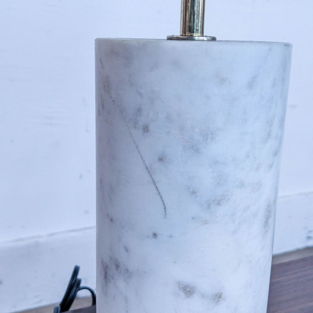 Detailed view of the marble cylindrical base with subtle natural markings.