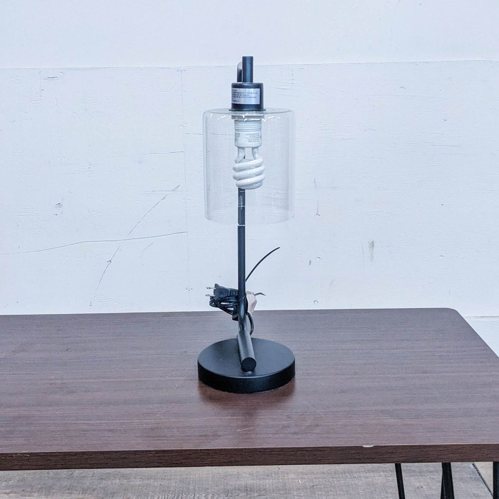 Side view of a Reperch lamp, featuring a modern design and compact black base.