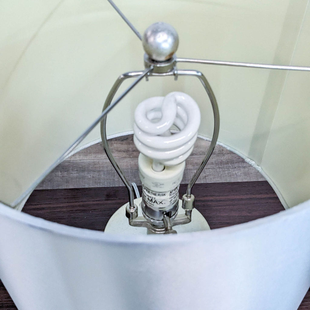 Close-up of the Reperch lamp showing the spiral bulb inside the silver shade.