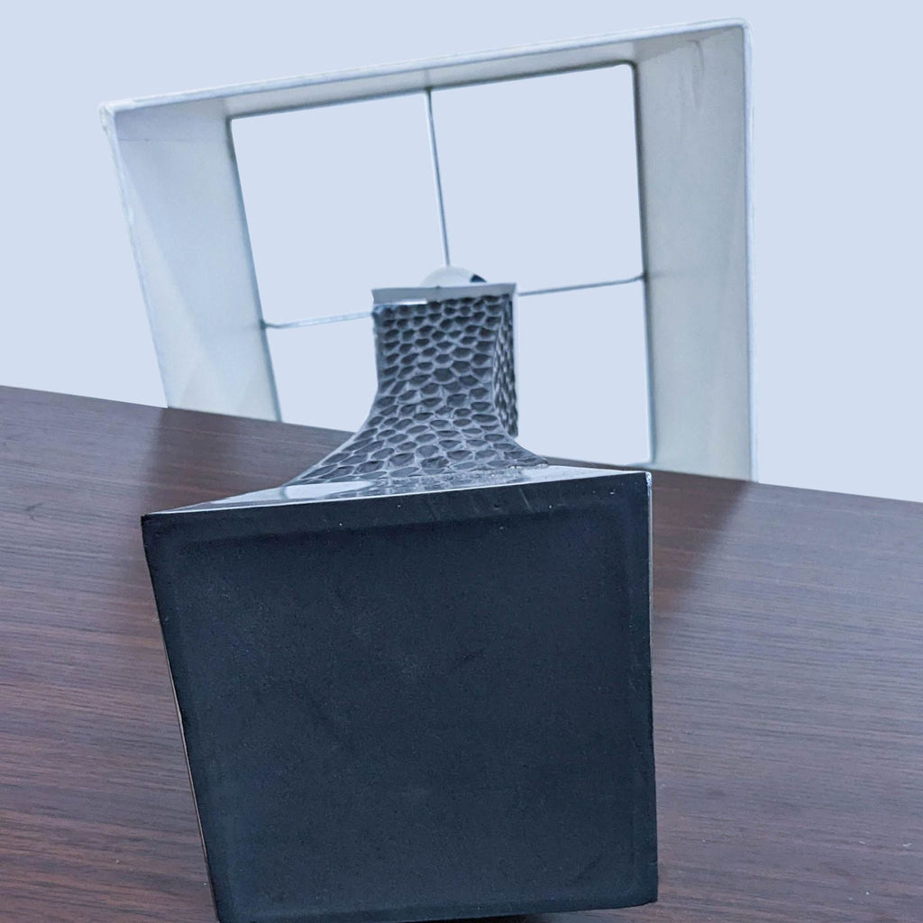Close-up view of the black textured base and square white lampshade.