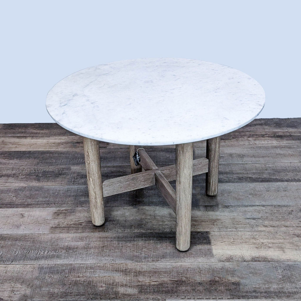 Round marble dining table with a Dune-finished wooden base by West Elm.