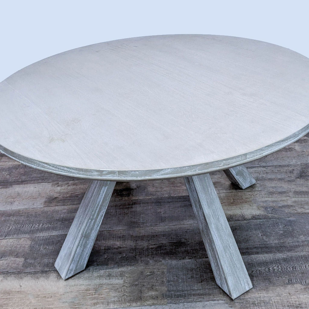 Solid acacia wood dining table by Zuo Modern, featuring a round top and flared legs in a sun-dried finish.