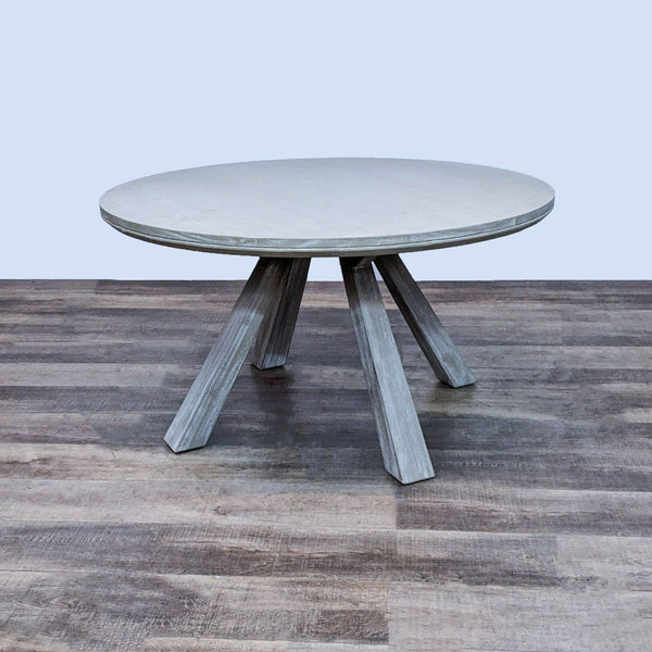 Round dining table by Zuo Modern with a bleached, coastal wood finish and flared legs.