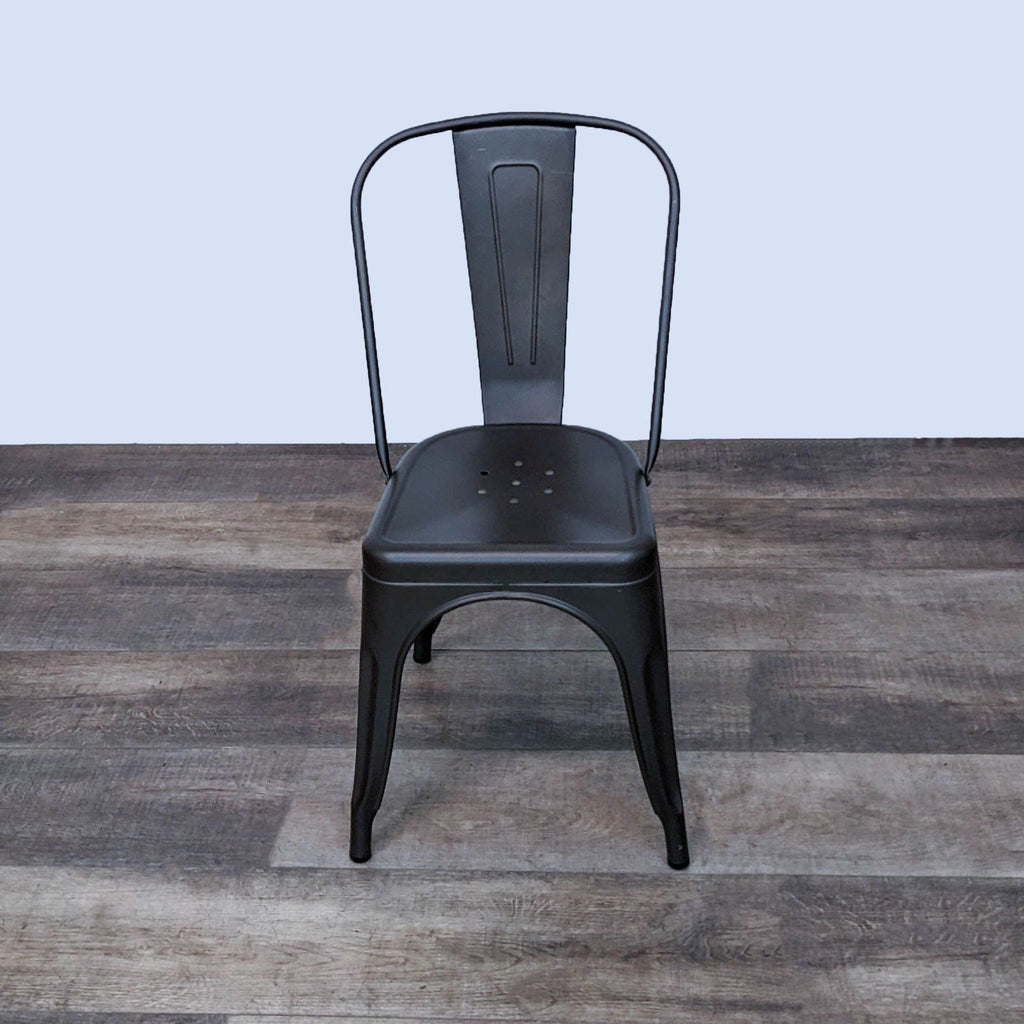 Industrial-style black metal dining chair with curved edges, front view.