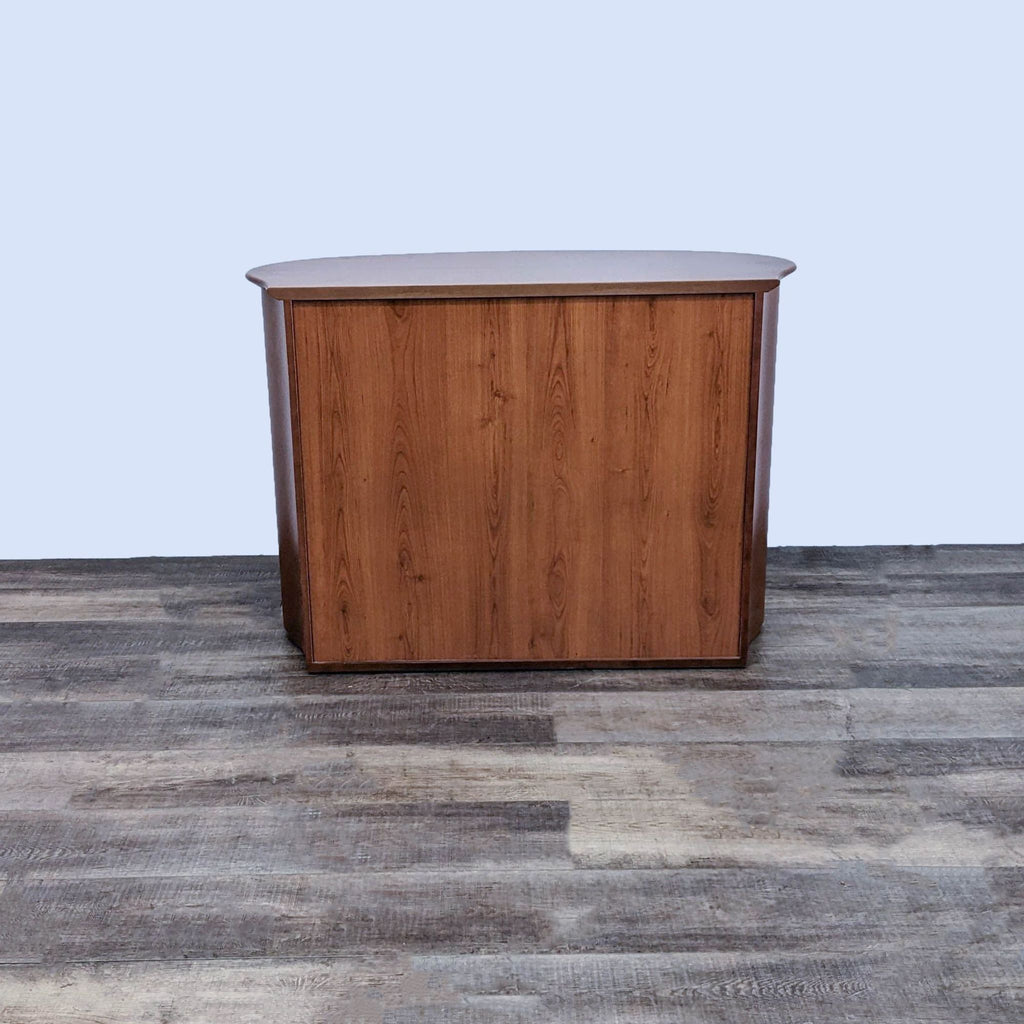 Back view of a cherry wood dresser with a sleek, curved top.