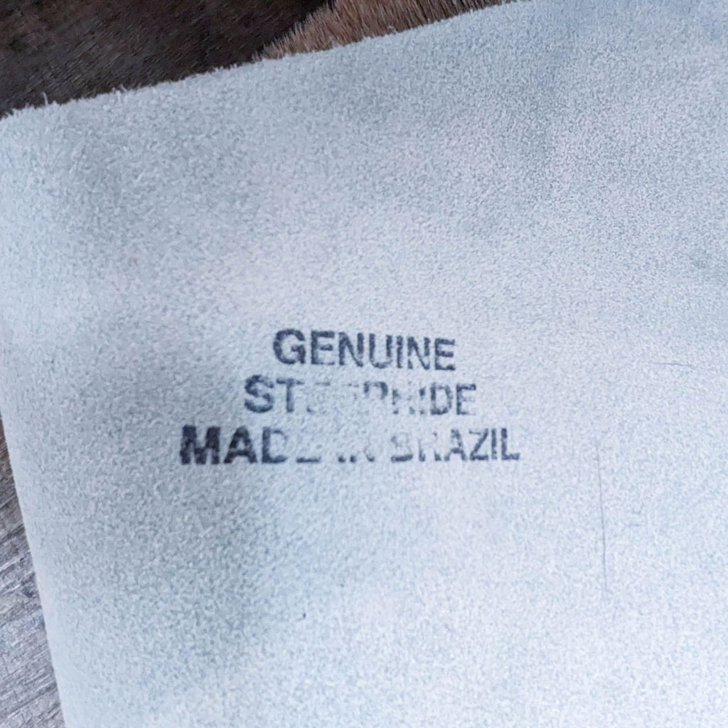 Label showing "Genuine Steer Hide Made in Brazil" on rug.