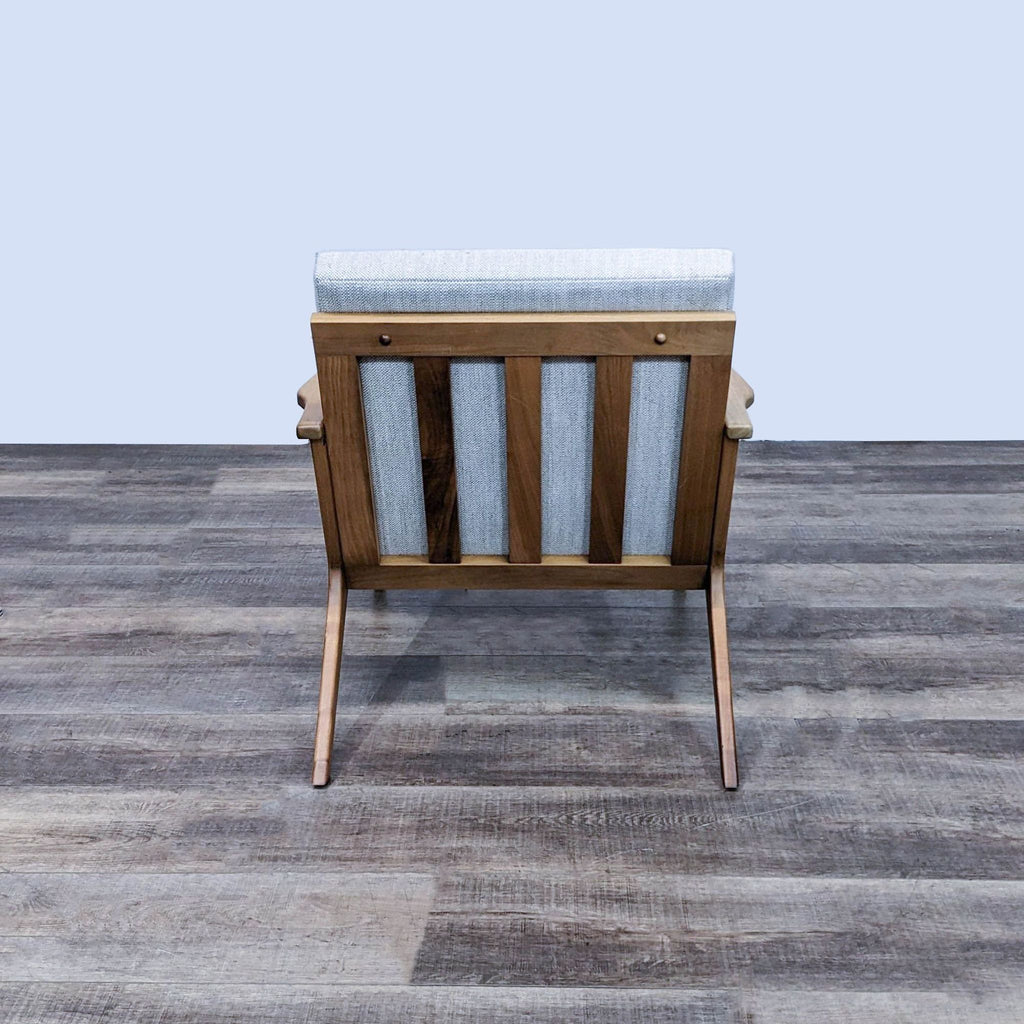 Rear view of Cavett chair by Crate & Barrel, showcasing solid walnut frame and cushioned back.