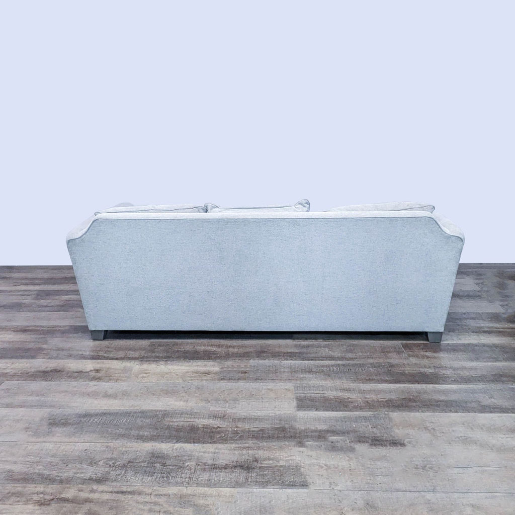Back view of Crate & Barrel off white sectional on wooden floor.  
