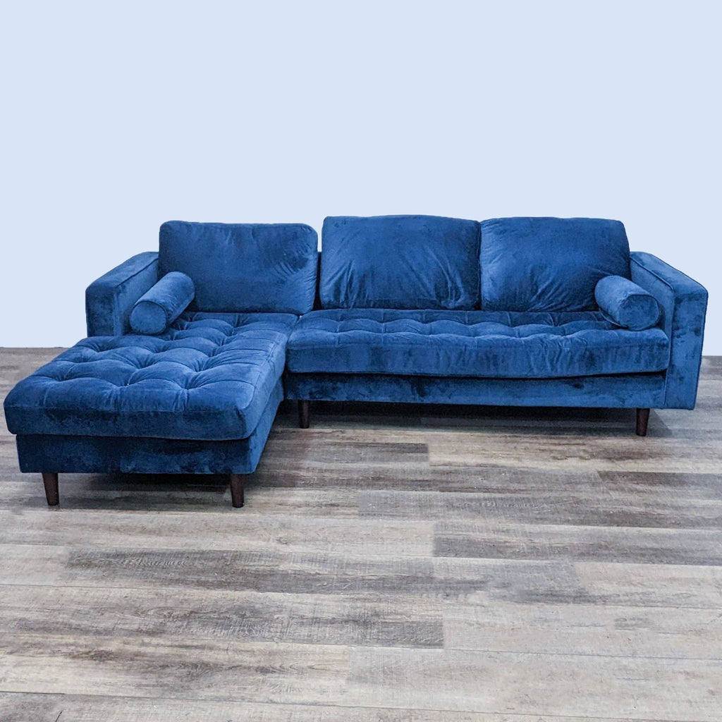 Blue Reperch two-piece tufted sectional with bolster pillows and dark legs, front view on wood floor.  