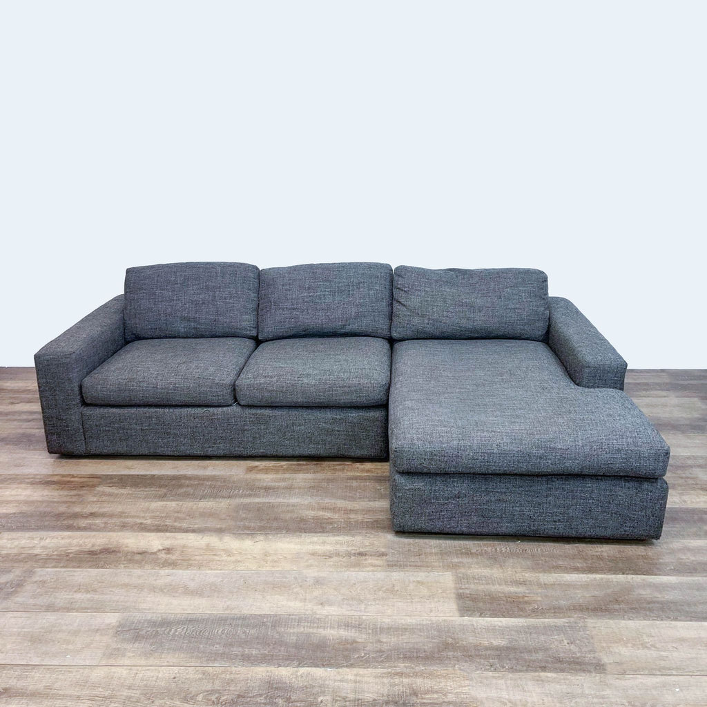 Gray two-piece sectional with chaise, featuring block arms and a modern fabric design.