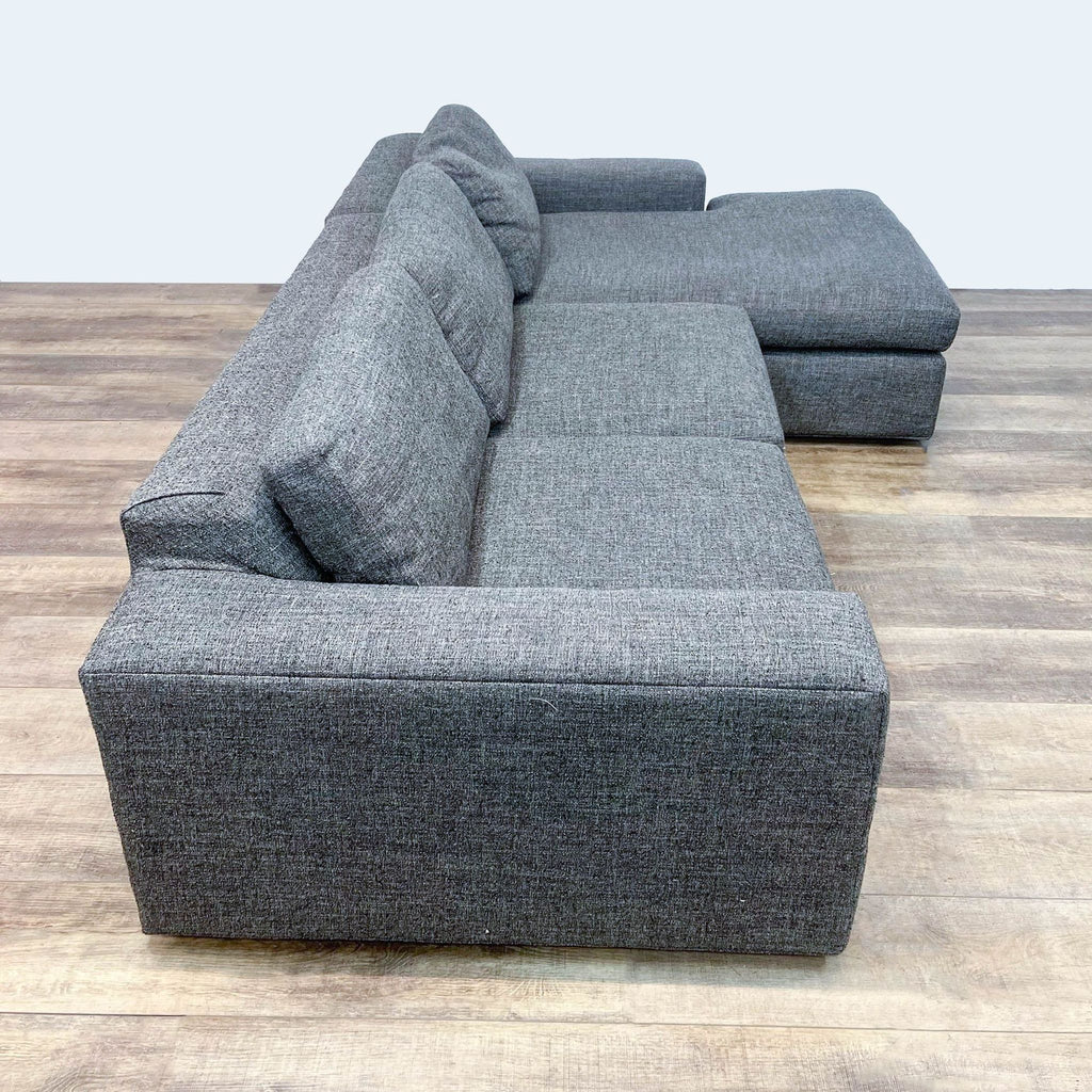 Modern gray fabric sectional with chaise and block arms, perfect for cozy living spaces.