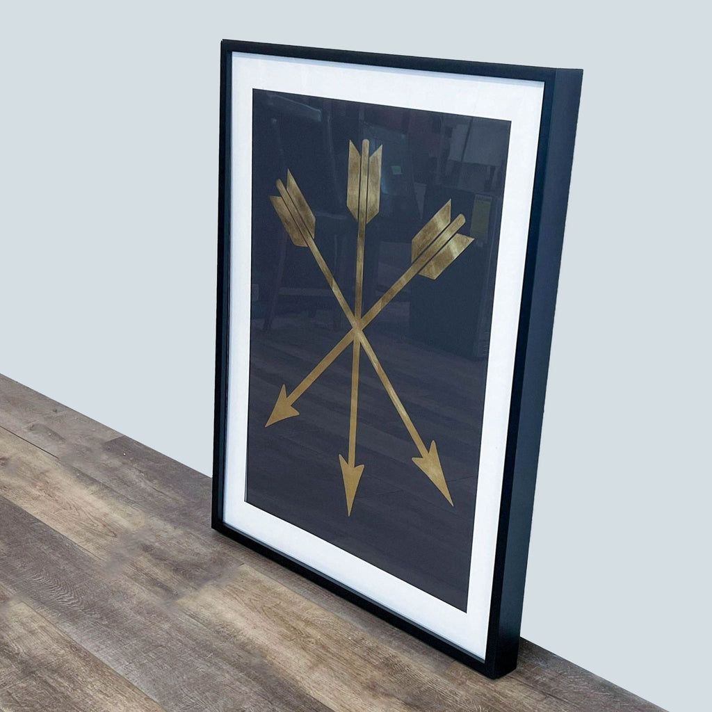 Art print of gilded arrows crossing on a dark background, presented in a black frame.