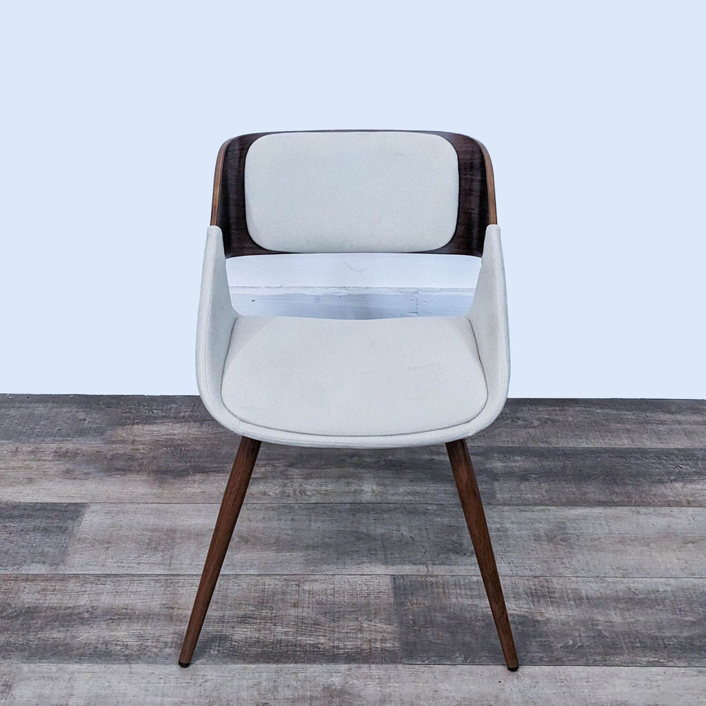 Front view of a mid-century Cyprus dining chair, featuring walnut legs and Santorini Sand upholstery.