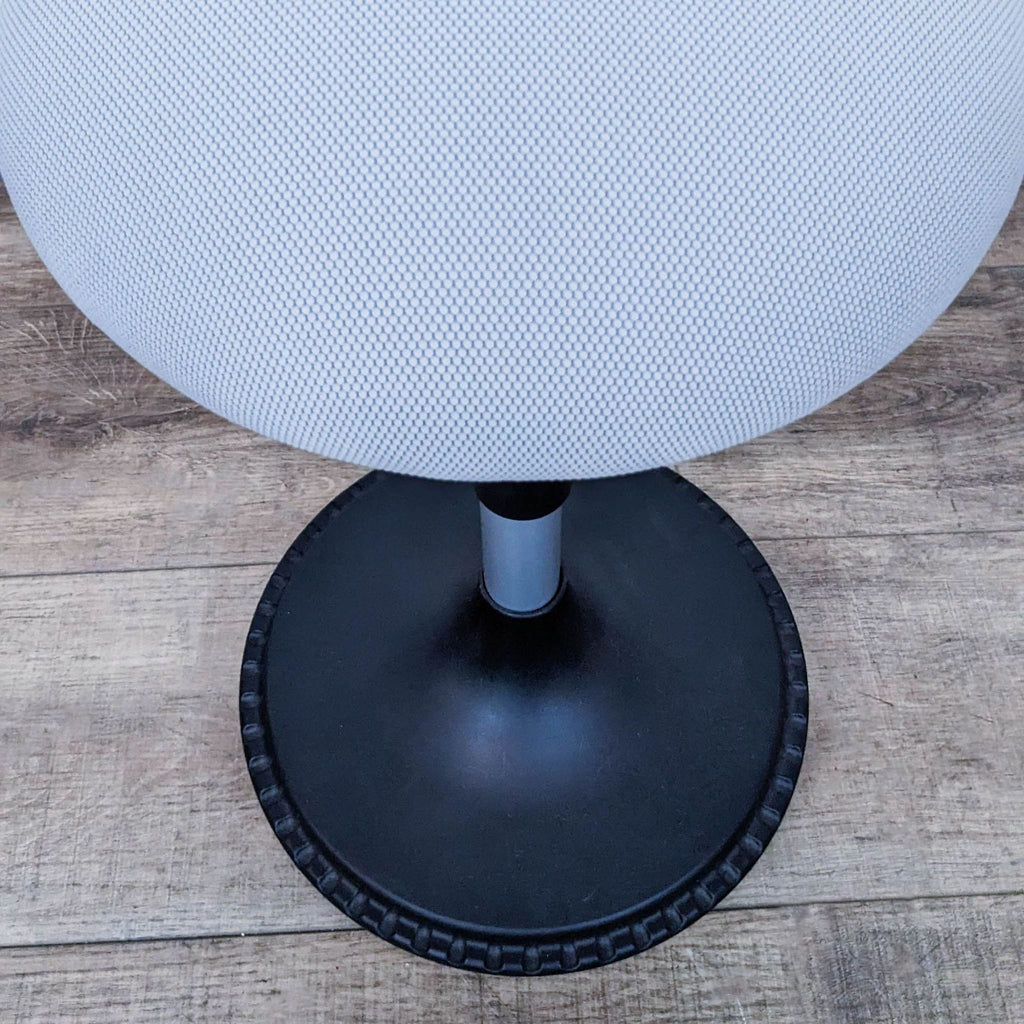Close-up of stool's padded seat and textured dark base.