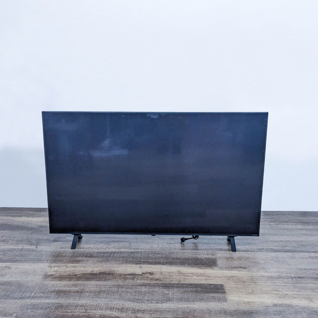LG TV with a blank screen on a wooden table.